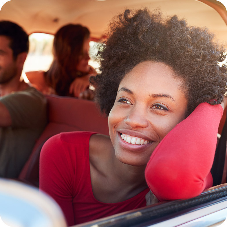 Pessoa sorrindo pela janela de um carro
