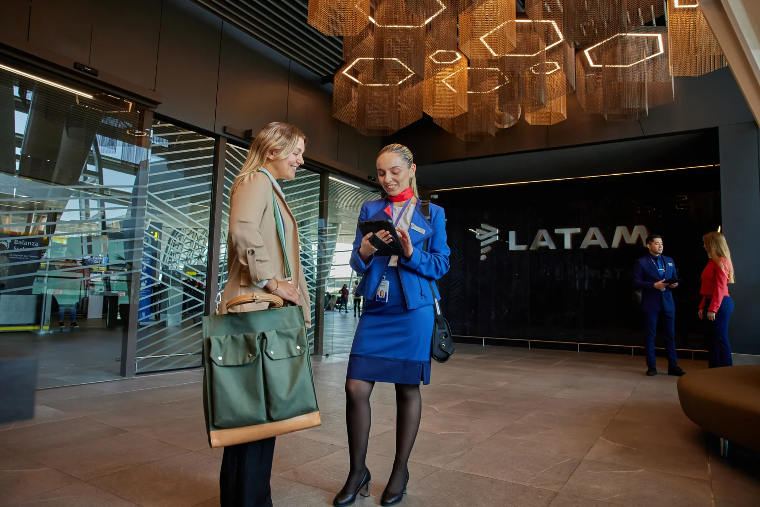 Funcionária LATAM atendendo uma passageira no aeroporto
