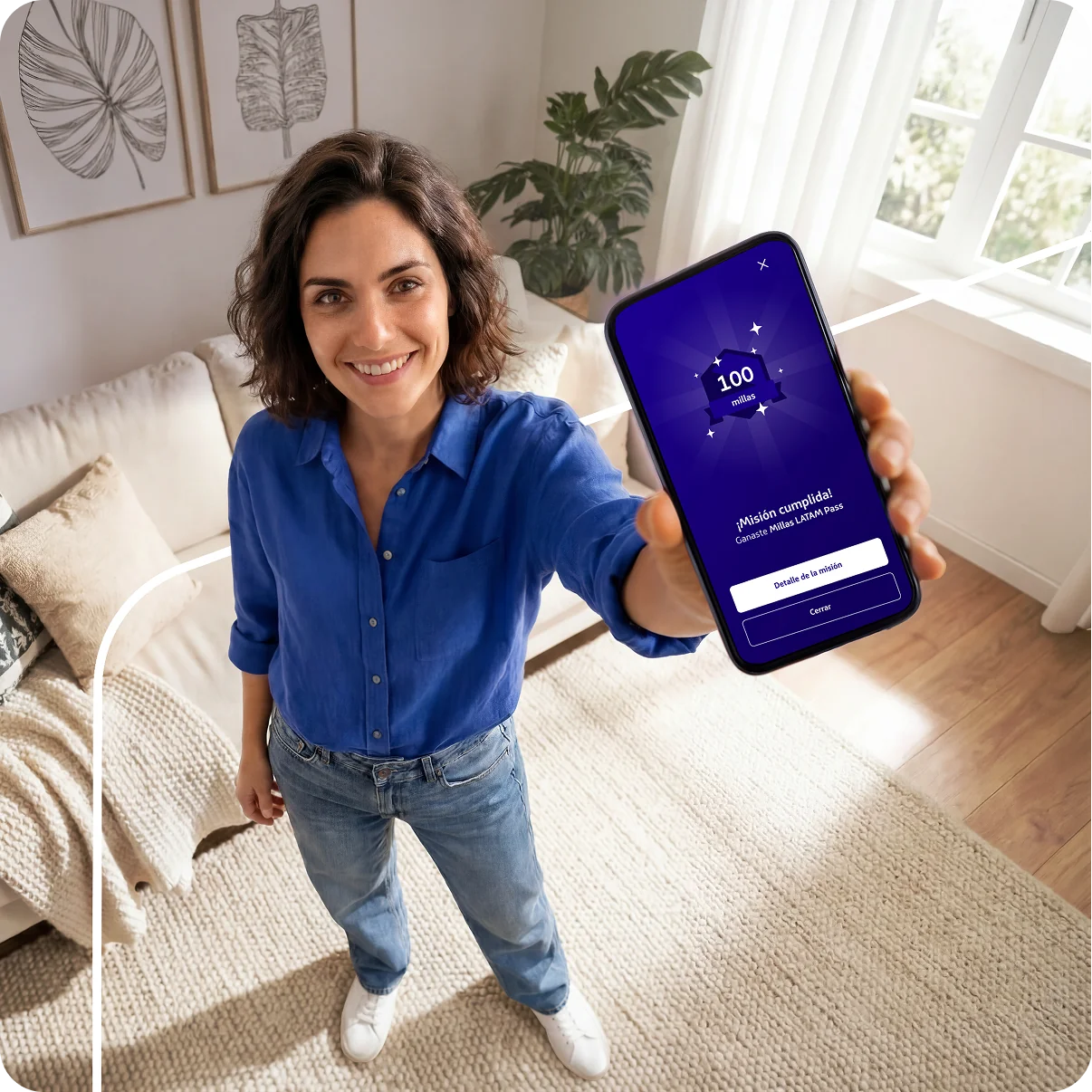 Mujer sonriendo mientras muestra en su celular una misión de 100 millas completada